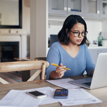 Woman reading financial documents at home