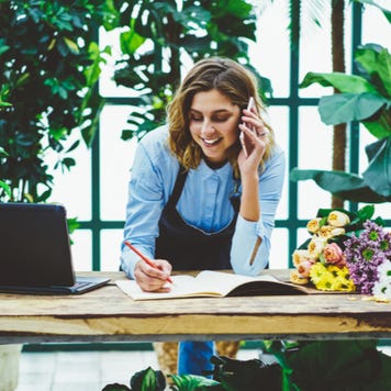 Florist works on paperwork while on the phone