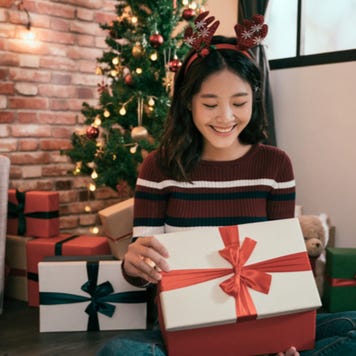 Young Asian woman opens Christmas gift box