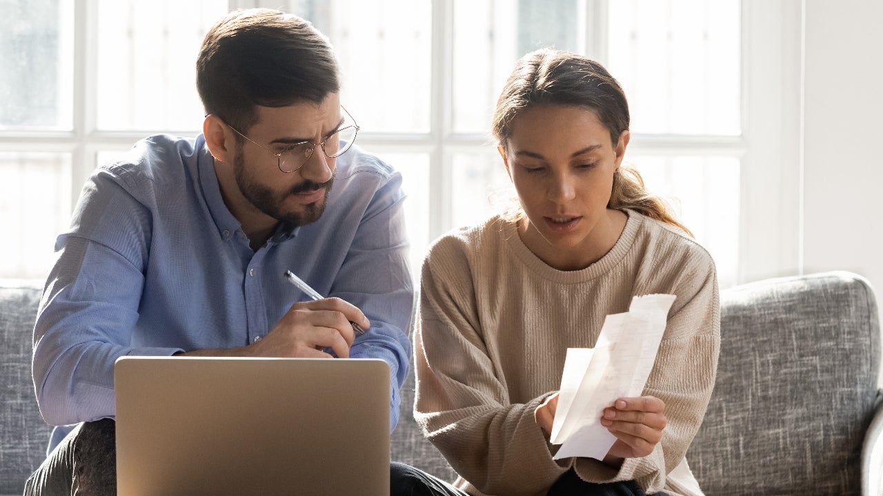 couple sitting on couch reviewing papers