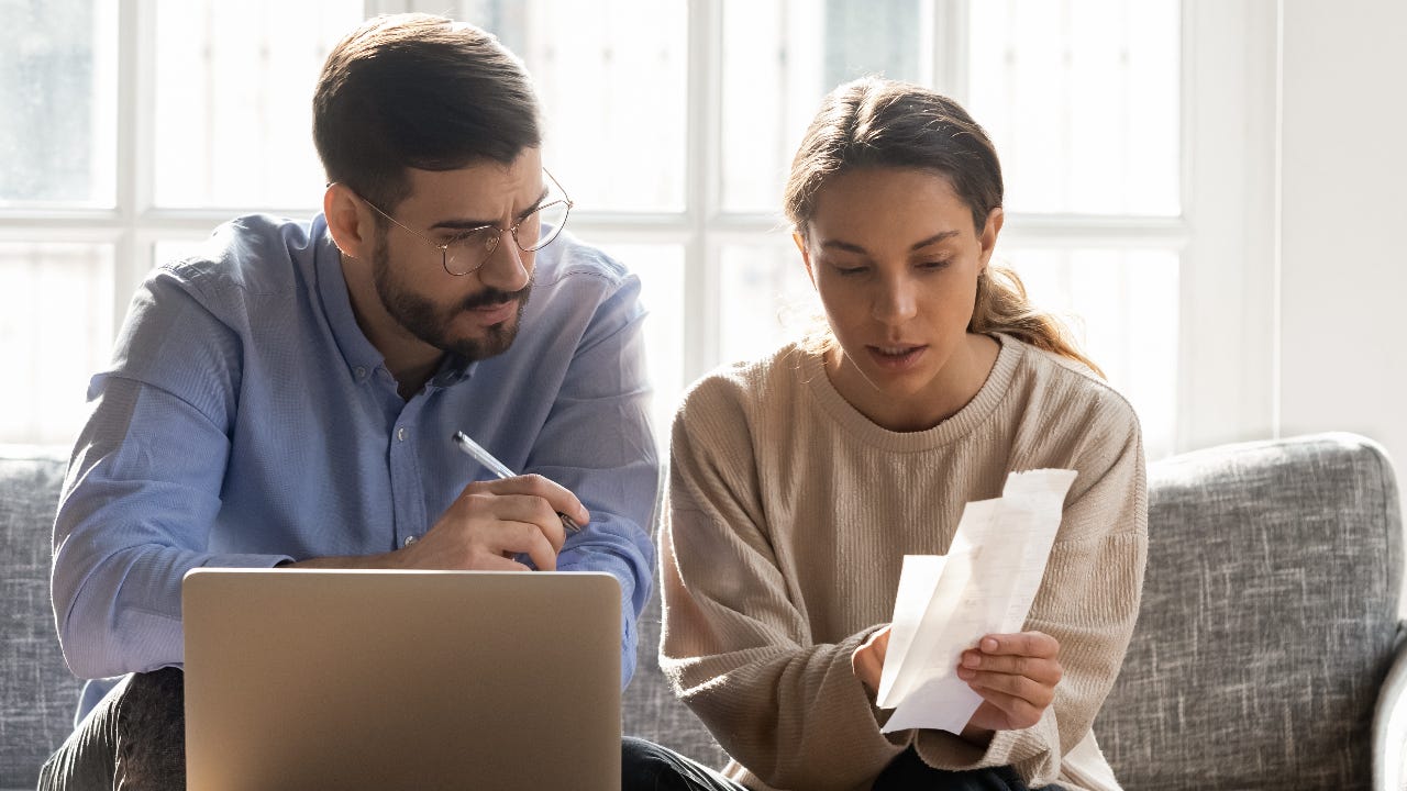 couple sitting on couch reviewing papers