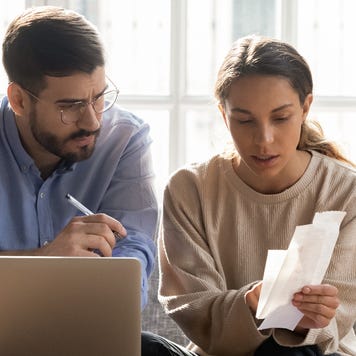 couple sitting on couch reviewing papers