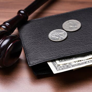 Wallet with money sitting next to judge gavel