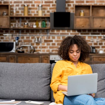 Young woman works on laptop from home