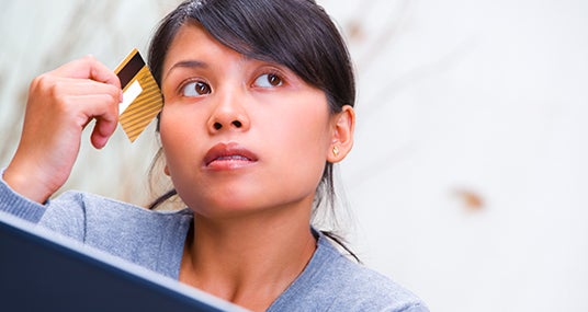 Woman thinking about credit card © Viktor Cap - Fotolia.com
