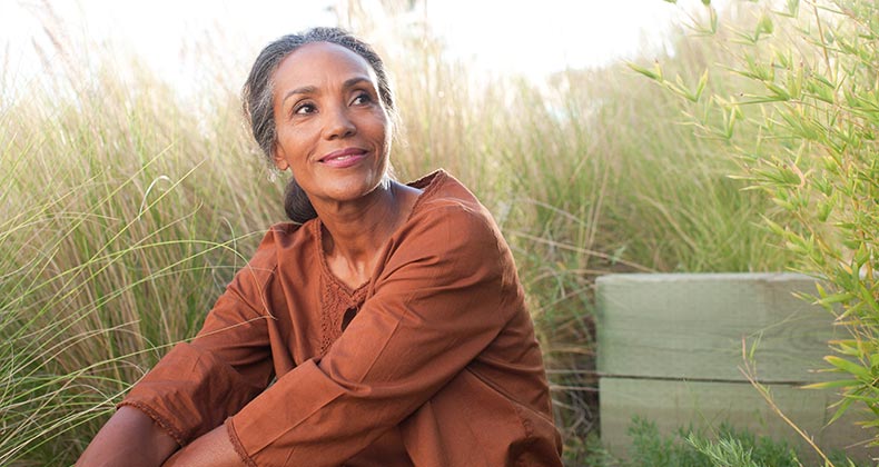 Older woman sitting outside | Tom Merton/Getty Images