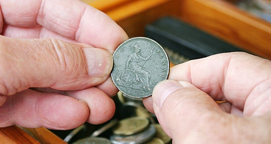 Man holding old 1901 British penny © Sue McDonald/Shutterstock.com