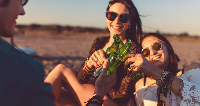 Friends clinking beer bottles together © Anchiy/Shutterstock.com