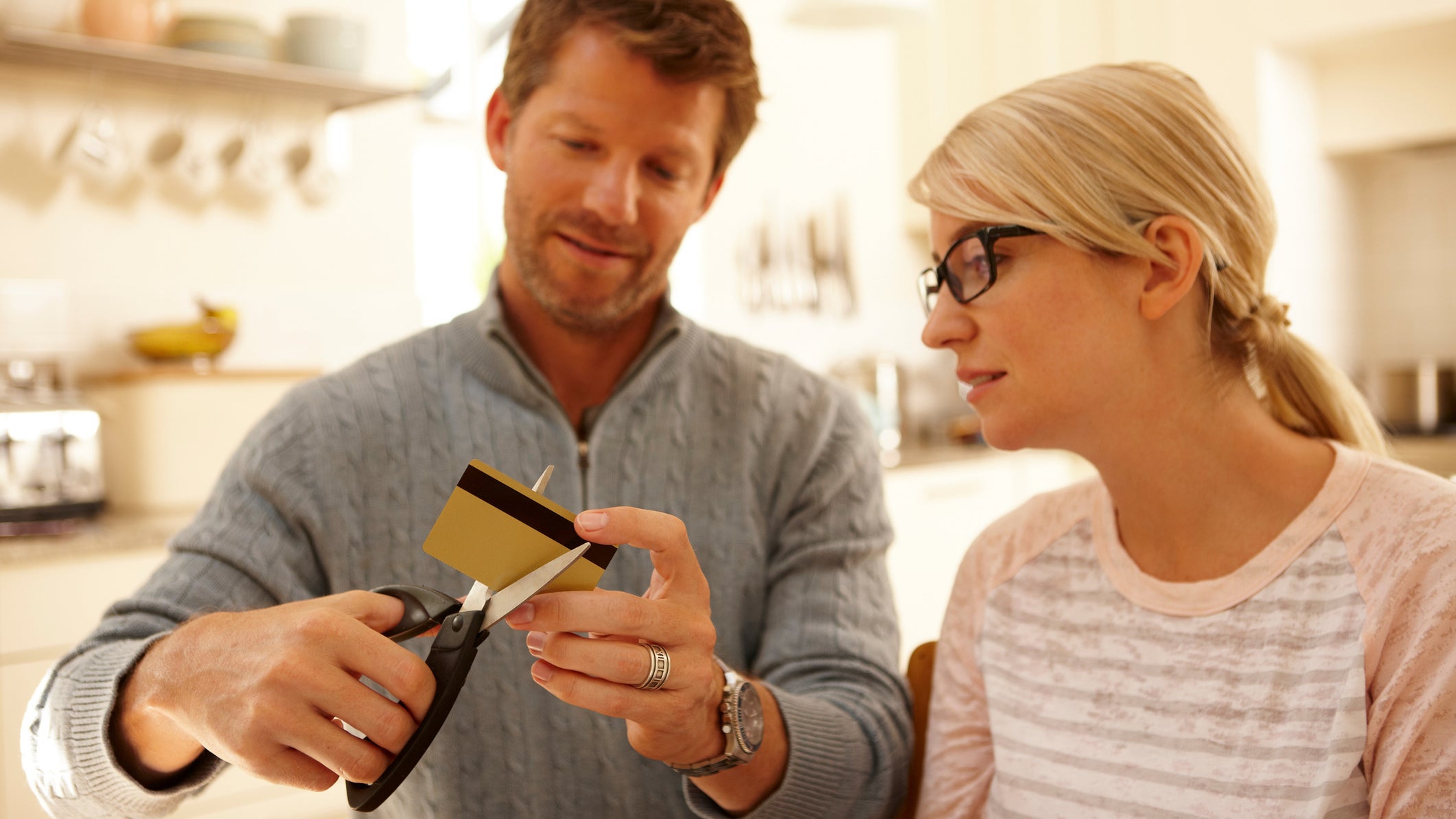Couple cutting credit card with scissors