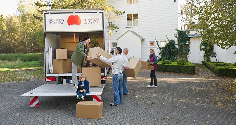 Group taking boxes off of the moving truck | Westend61/Getty Images