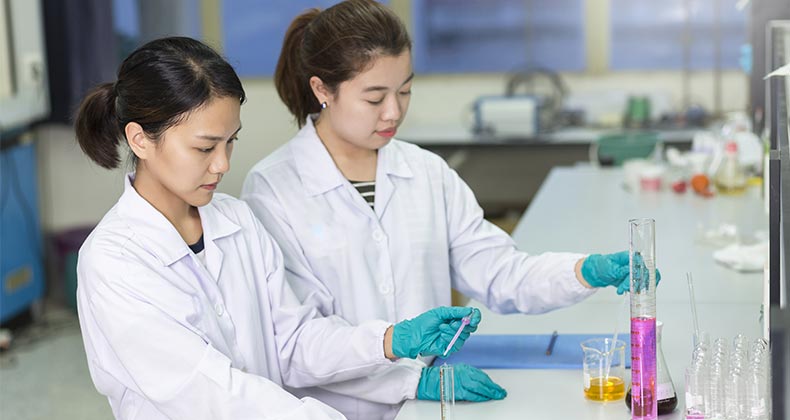 Two chemists measuring liquids | MeemiePhoto/Shutterstock.com