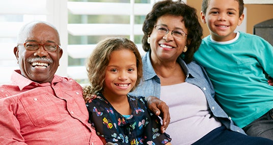 Grandparents and grandchildren sitting on couch © Monkey Business Images/Shutterstock.com