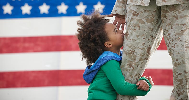 Child hugging military parent's leg | LWA/Dann Tardif/GettyImages