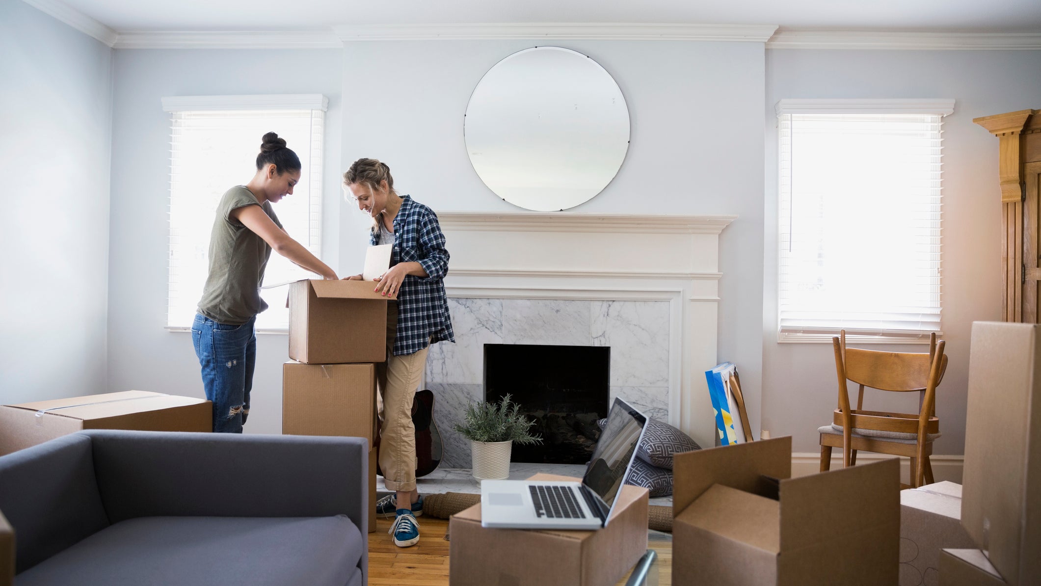 Lesbian couple unpacking moving boxes in living room