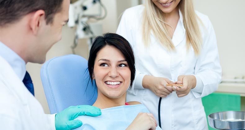 Woman in dentist's chair getting cleaning | Lucky Business/Shutterstock.com
