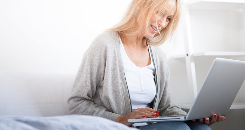 Woman smiling using her webcam © iStock