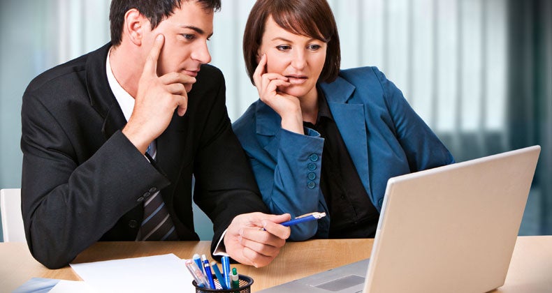 Couple sitting at a table looking at a computer © Patrizia Tilly/Shutterstock.com