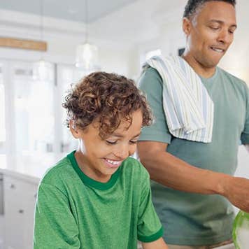Dad and son doing dishes in kitchen | Hero Images/Getty Images