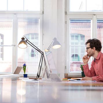 Man sits at his desk looking at computer