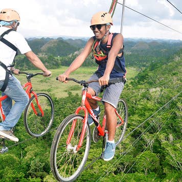 Two men biking on ziplines