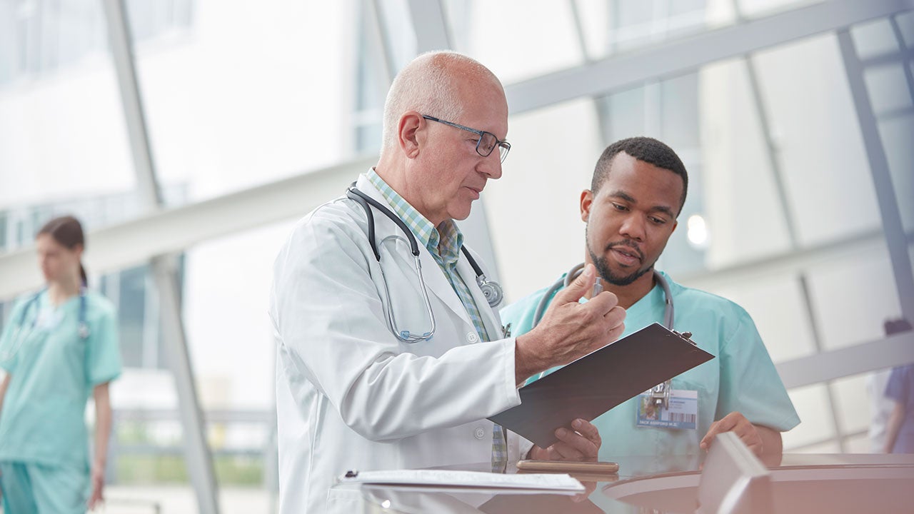 Older doctor talking with nurse