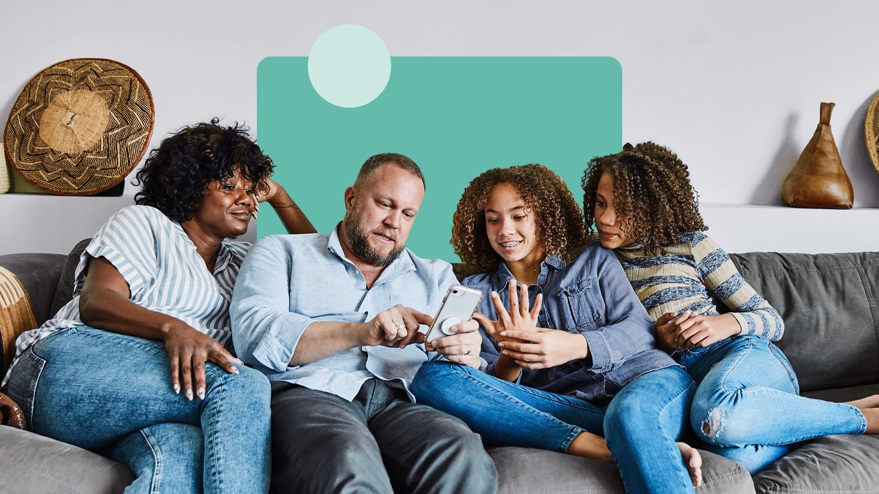 family sitting on a couch on mobile device