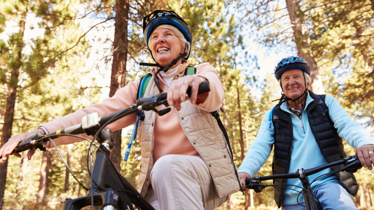Couples rides bike through forrest