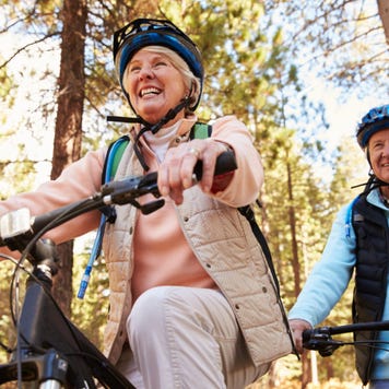 Couples rides bike through forrest
