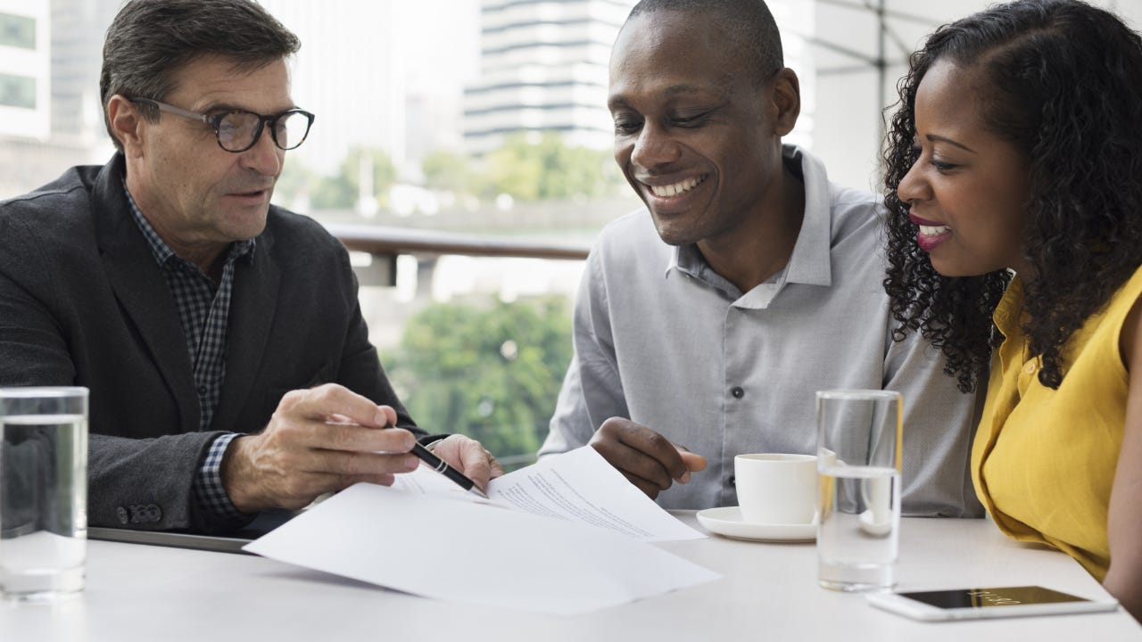 A man explains retirement options to a younger couple