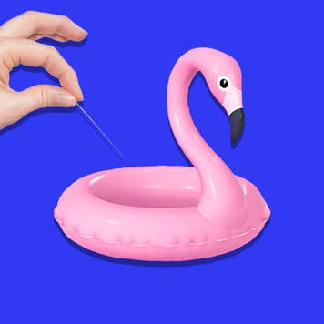 Woman with needle puncturing a flamingo floaty