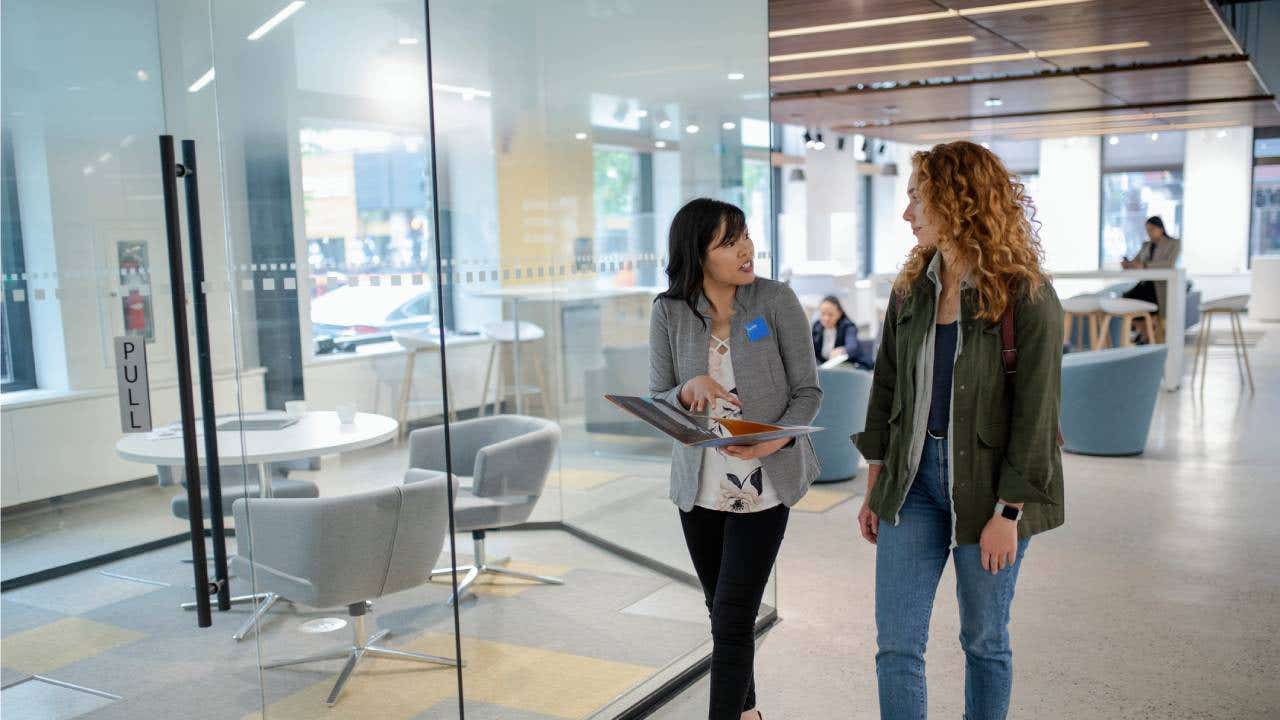 loan manager with paperwork talking with client in bank branch