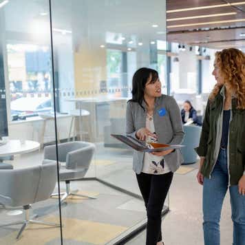 loan manager with paperwork talking with client in bank branch