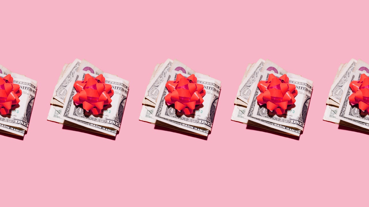 Row of folded dollar bills with red gift bows