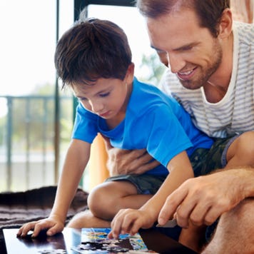 Father and young son do puzzle together