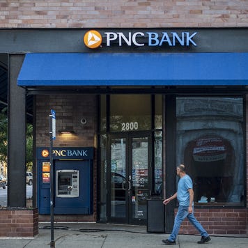 A pedestrian walks by a bank branch.