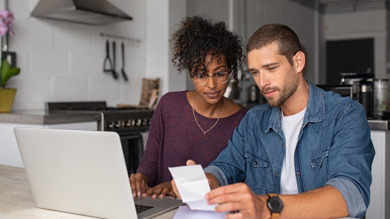 couple sitting at table going over receipts together
