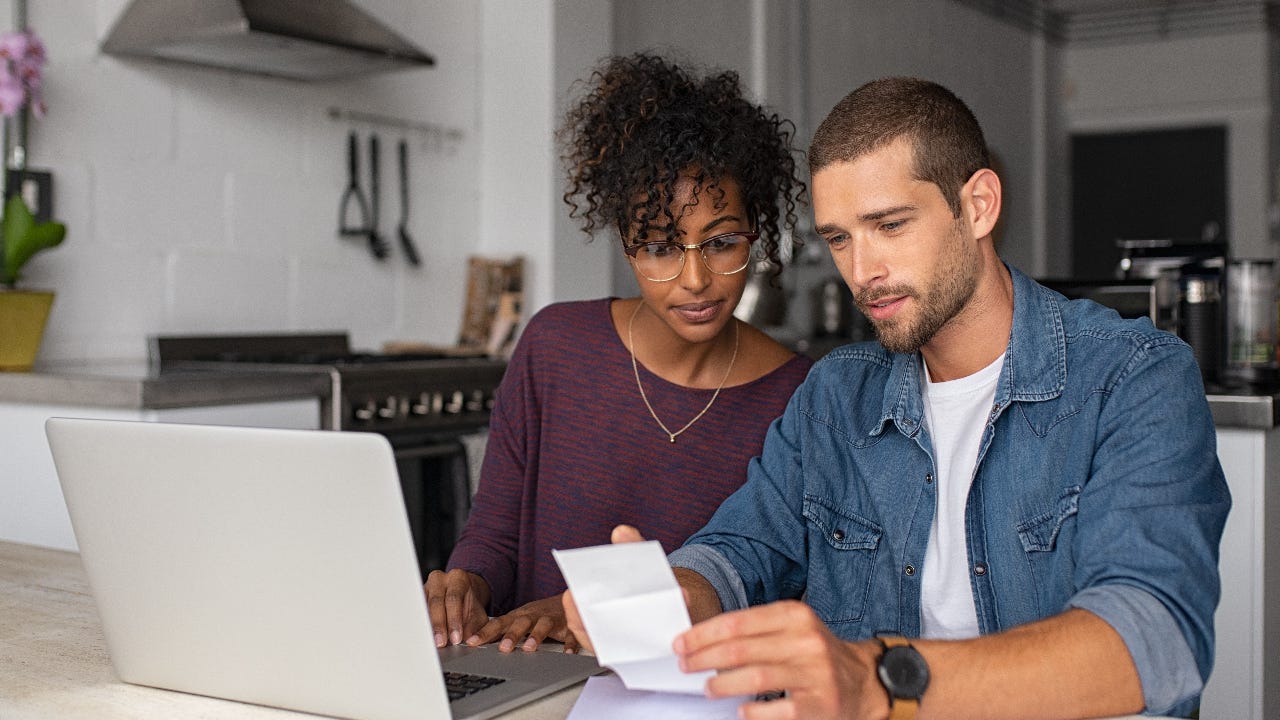 couple sitting at table going over receipts together