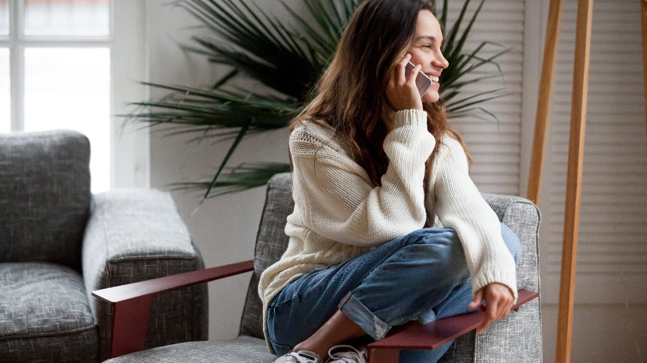 young woman at home talking on cell phone