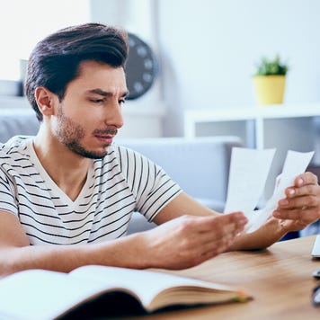 man sitting at home reviewing receipts
