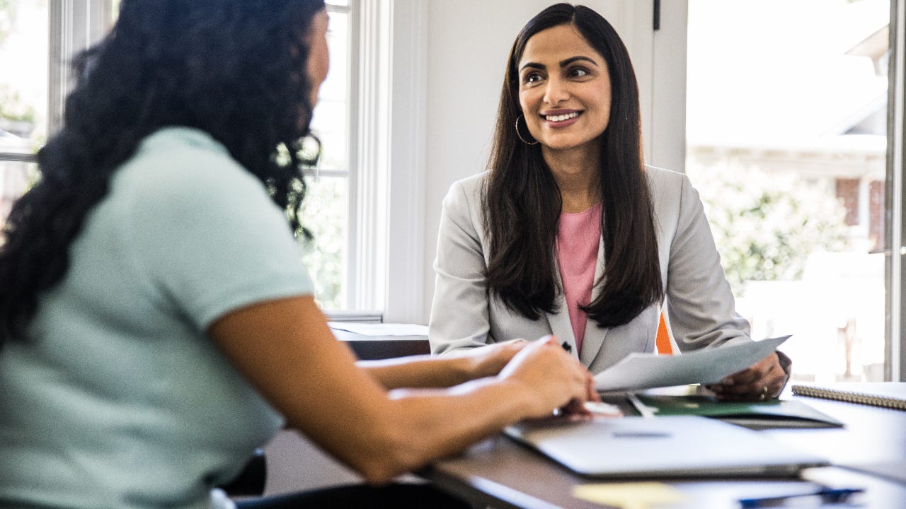 A woman meets with her lender to refinance her mortgage.
