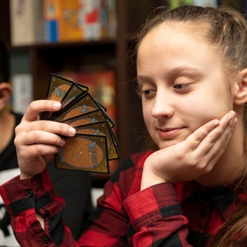 Girl plays Magic: The Gathering game