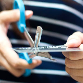 Woman cutting an old credit card with scissors