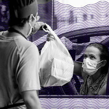 A restaurant worker hands a bag to a woman with a facemask
