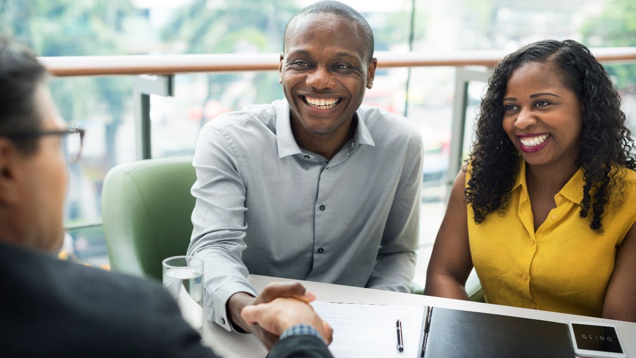 A couple meets with their lender to close on their mortgage