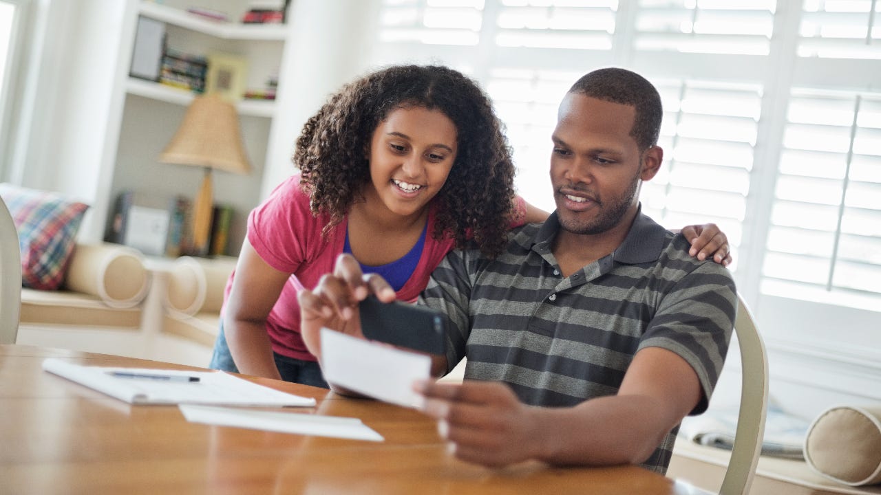 Daughter and father using mobile phone