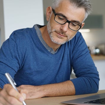 Person on computer also writing