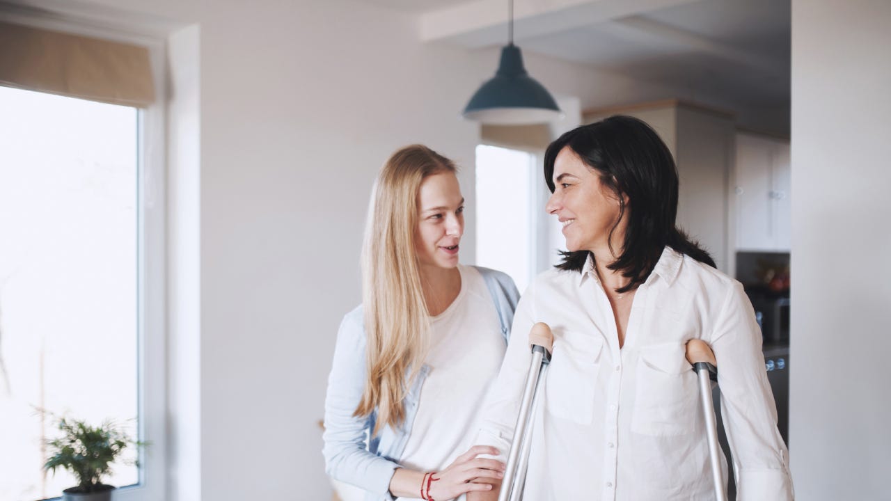 Daughter helps mother adjust to her new crutches.