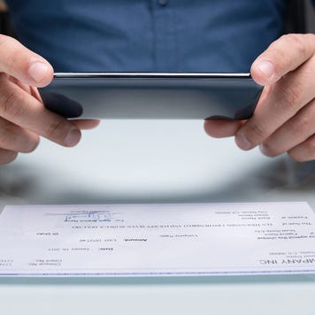 A person takes a picture of a check.