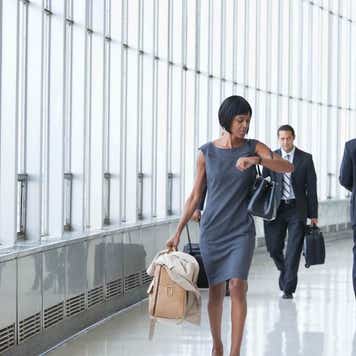 Black businesswoman checking the time on wristwatch in corridor