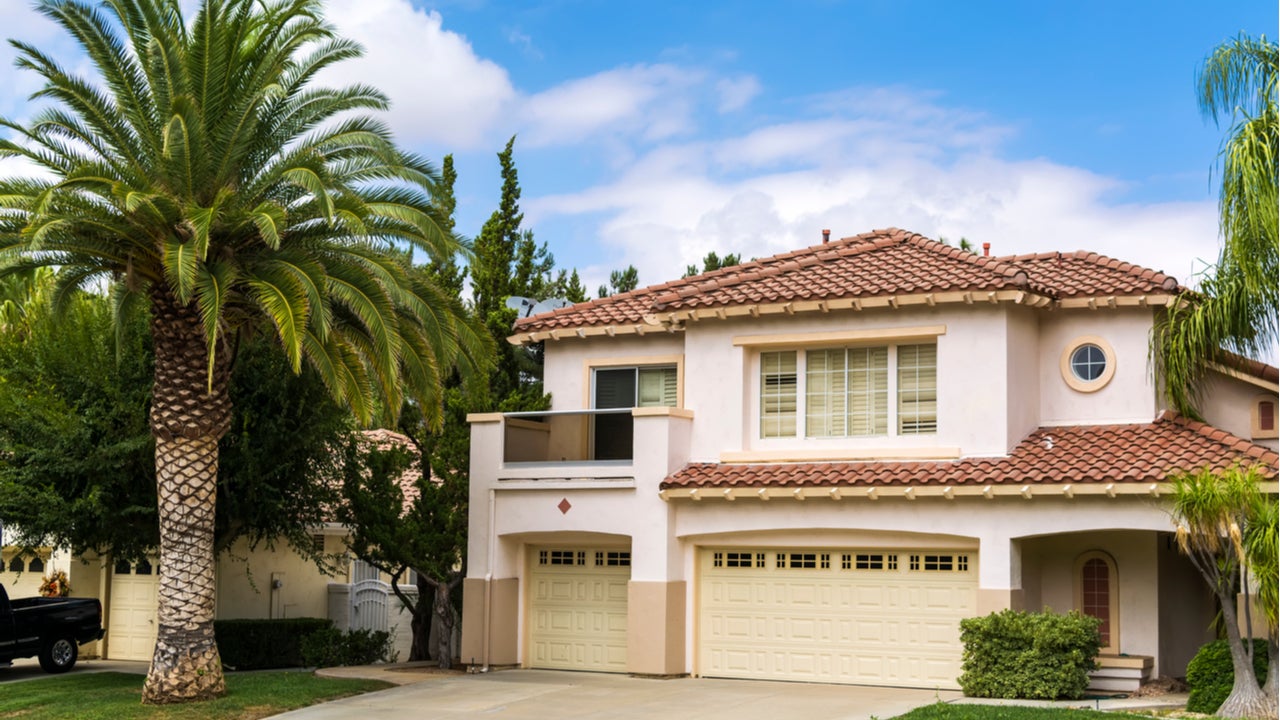 A Mediterranean-style single-family home with landscaping